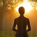 A person in comfortable activewear stretching gracefully outdoors at dawn, indicating fitness and movement