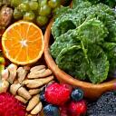 A vibrant bowl of fresh fruits, nuts, and greens, representing healthy nutrition